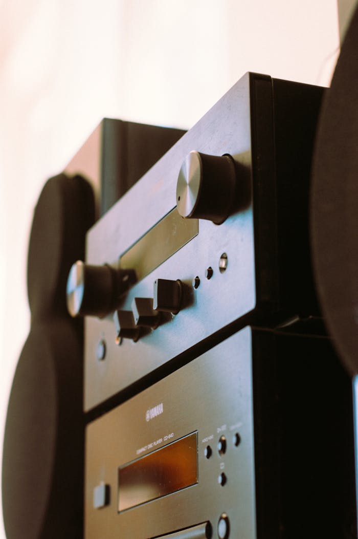 A detailed view of a sleek black audio stereo system highlighting control knobs.